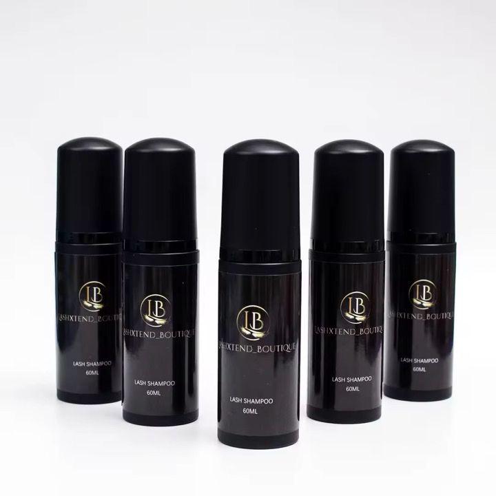 Cinco frascos Lash Shampoo LashXtend Boutique en envases negros con diseño cilíndrico, alineados en formación curva. Fórmula profesional para limpieza de pestañas antes de extensiones, ideal para lash artists que buscan higiene, precisión y estética boutique.